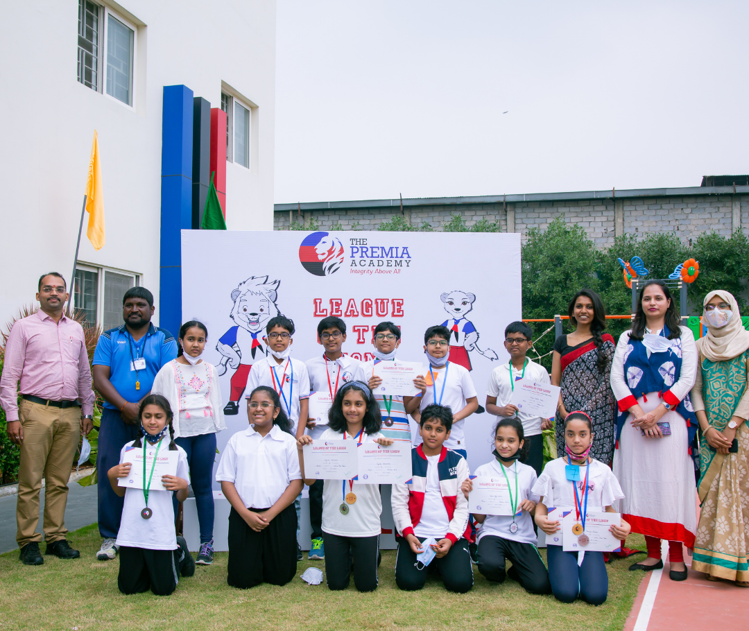 Premia Academy League of the Lions competition winners posing with their medals and certificates outdoors