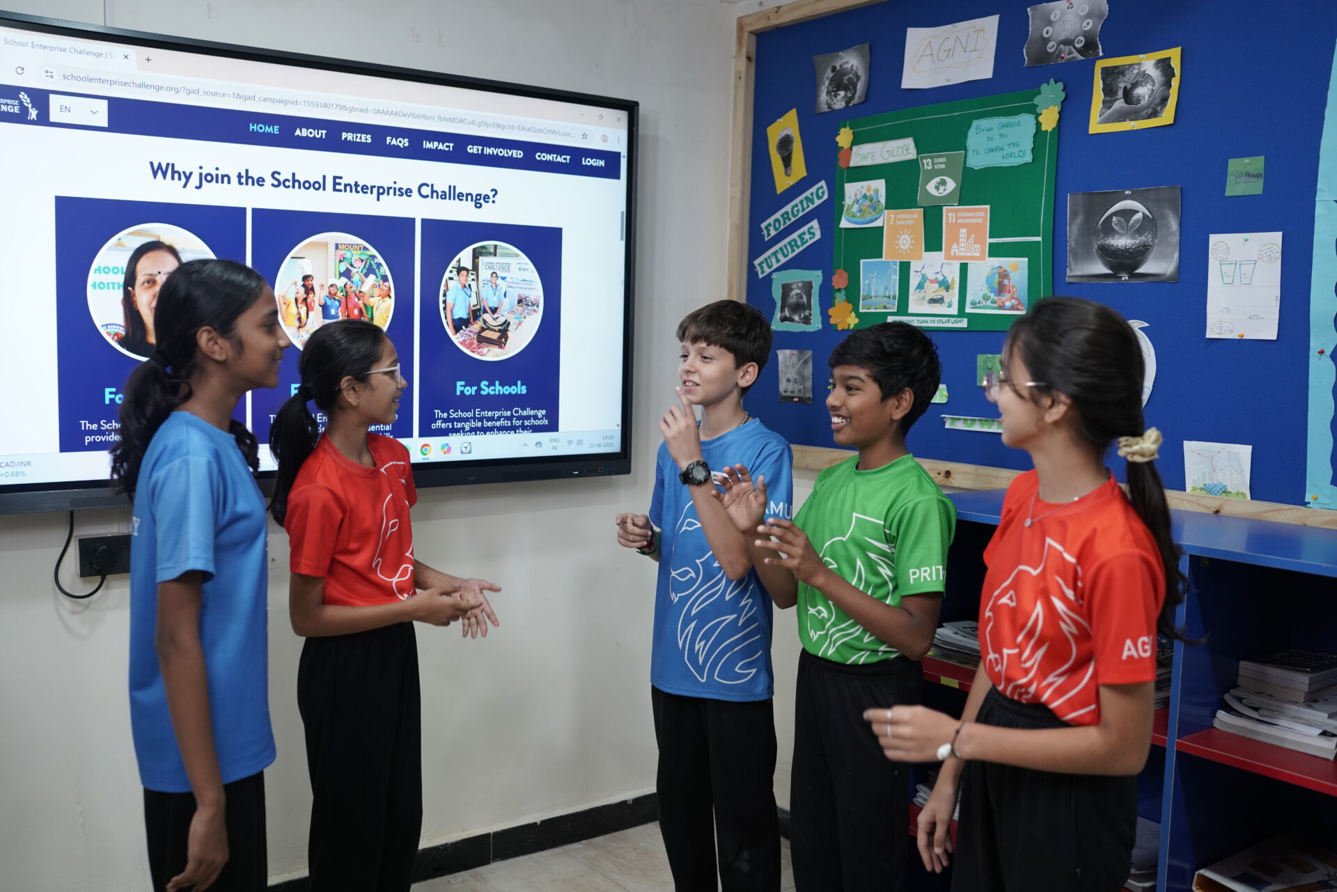 Premia Academy students engaging in a team discussion and high-fives, preparing for the School Enterprise Challenge entrepreneurship program.