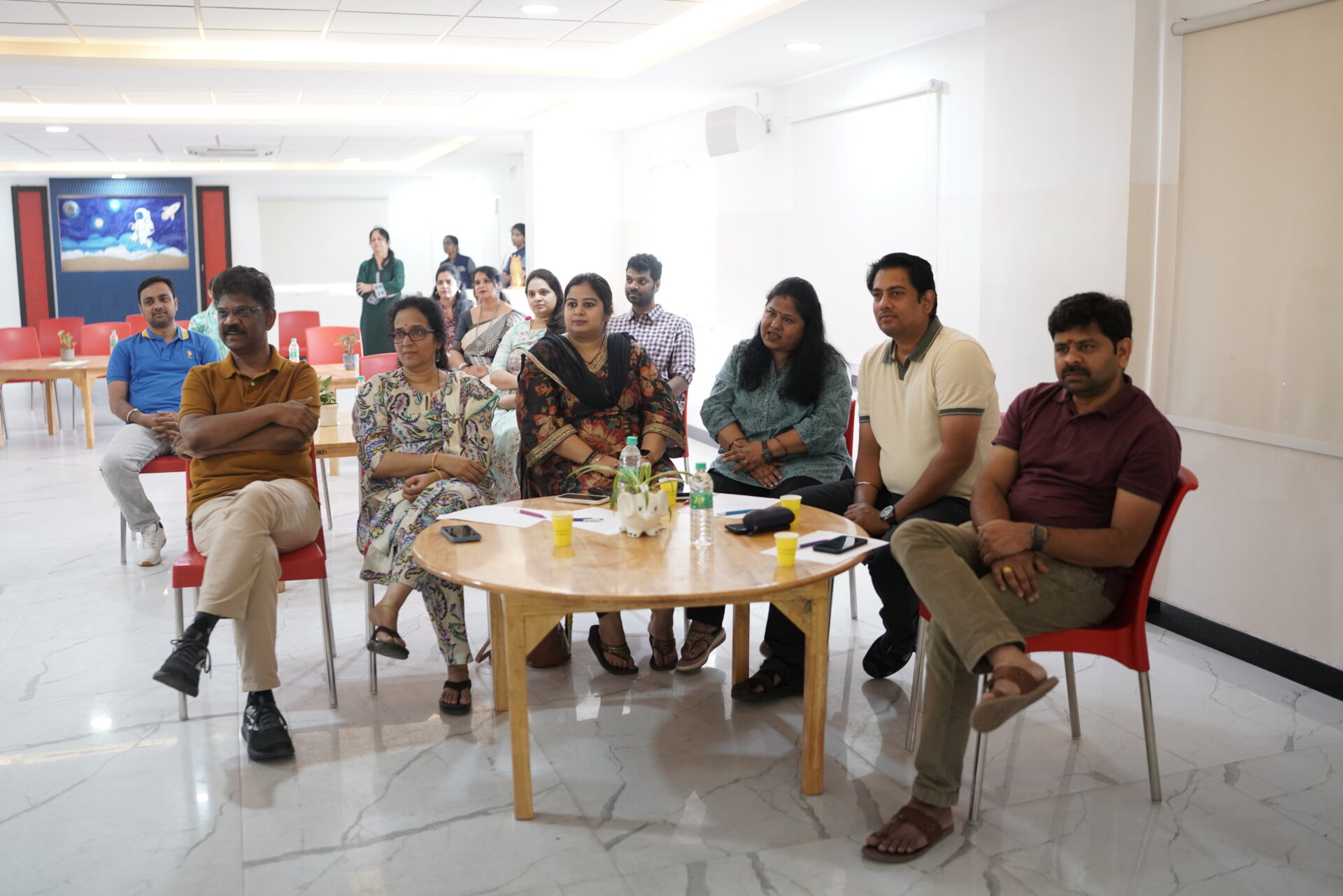 Group of parents and faculty sit around a small table during a school meeting or orientation session