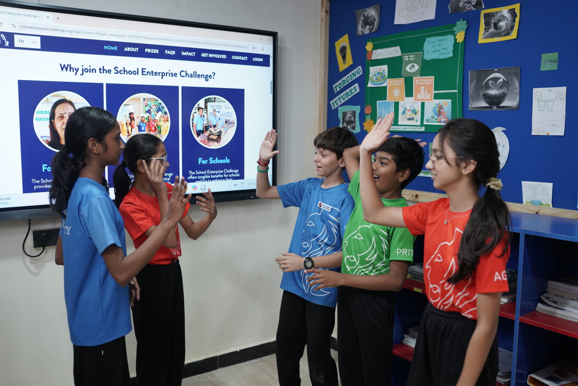Premia Academy students engaging in a team-building exercise with high-fives during the School Enterprise Challenge entrepreneurship program.