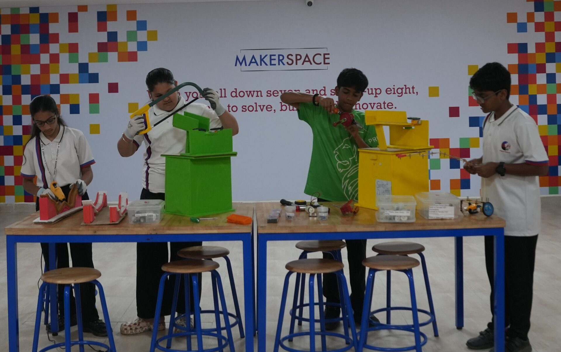 Four students building and working on science projects in the school's Makerspace lab