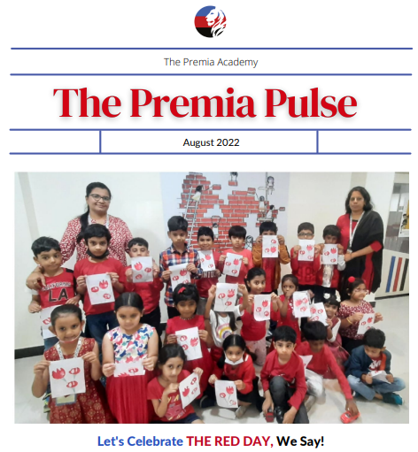 primary students and teachers holding up art work for the 'Red Day' theme celebration